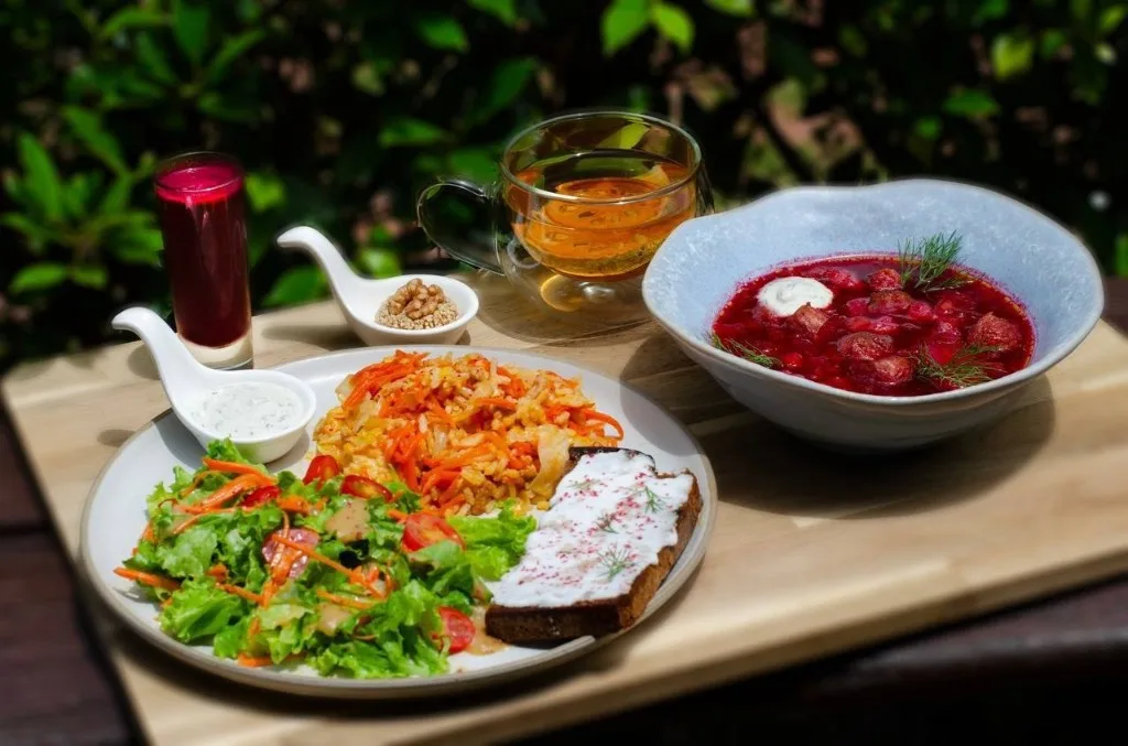 Vegetarian plate with beet soup, salad, and fresh juice