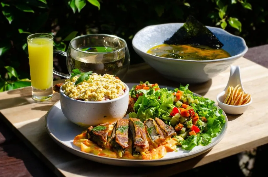 Vegetarian plate with soup, salad, and fresh juice
